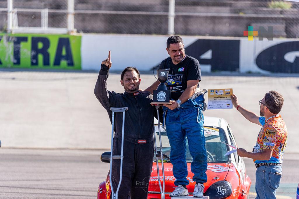 Carlos Cordero de OAM le entrega reconocimiento a Erick Rojas, a su lado su coequipero Ángel Lozano, ambos pilotos ganadores en Turismo Mayor.